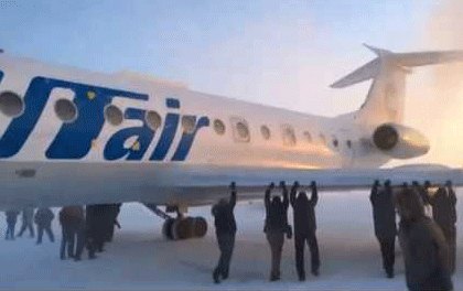 Russian passengers push plane on ground